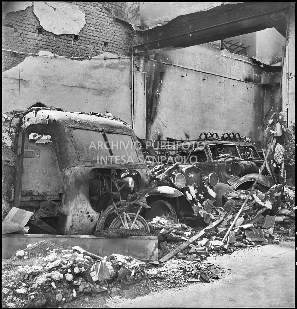 Interno di un'autorimessa colpita dai bombardamenti che hanno distrutto le automobili ricoverate