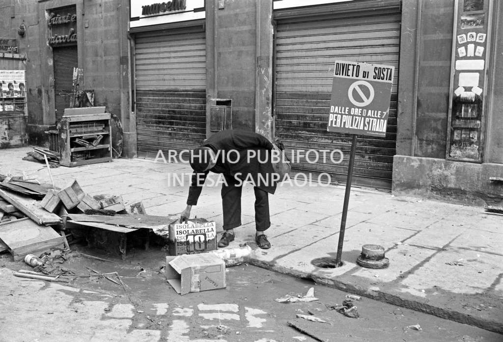 Un uomo controlla alcuni oggetti abbandonati lungo una strada