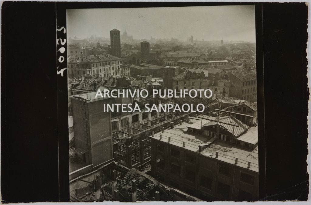 Ripresa dall'alto del complesso di edifici della sede centrale della Rinascente, in via Carducci a Milano, gravemente danneggiato dai bombardamenti. Sullo sfondo la basilica di Sant'Ambrogio
