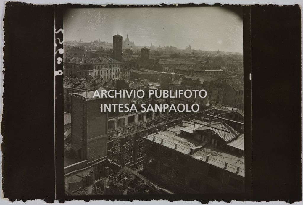 Ripresa dall'alto del complesso di edifici della sede centrale della Rinascente, in via Carducci a Milano, gravemente danneggiato dai bombardamenti. Sullo sfondo la basilica di Sant'Ambrogio