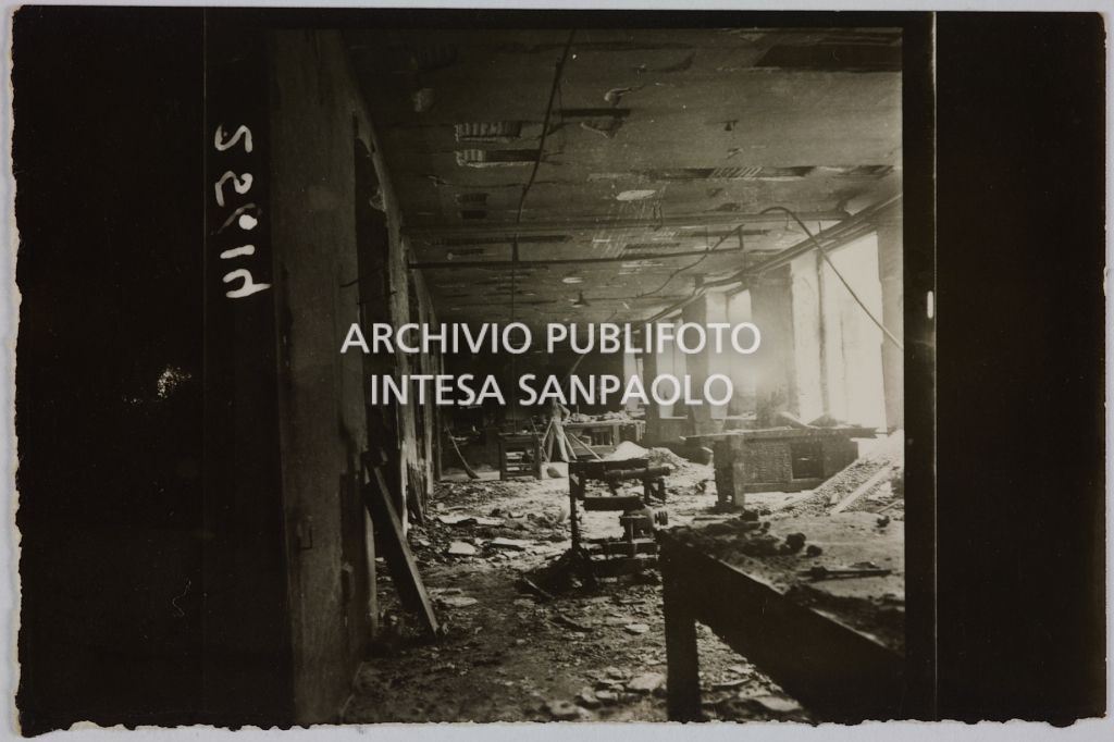 Interno di un edificio della sede centrale della Rinascente, in via Carducci a Milano, danneggiato dai bombardamenti e ingombro di macerie, detriti, mobili e attrezzature. Sullo sfondo un uomo