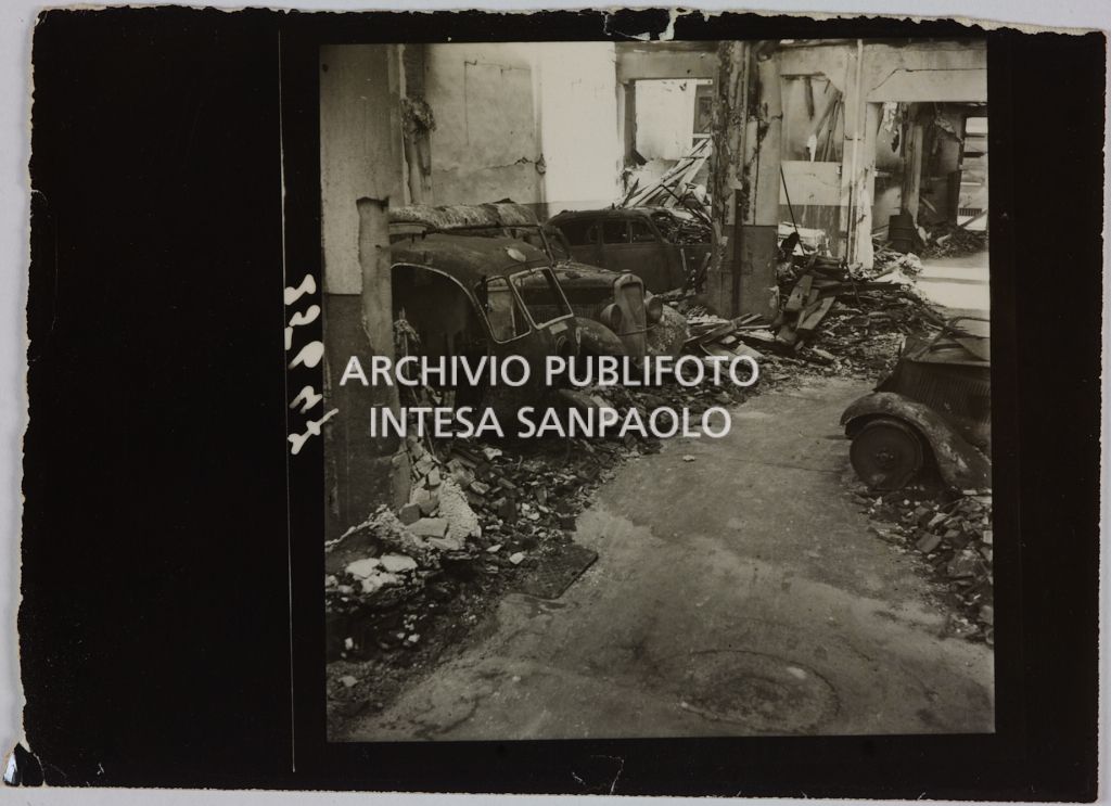 Automezzi ricoverati presso l'autorimessa di proprietà della Rinascente, in viale Coni Zugna a Milano, distrutti dai bombardamenti che hanno colpito l'edificio