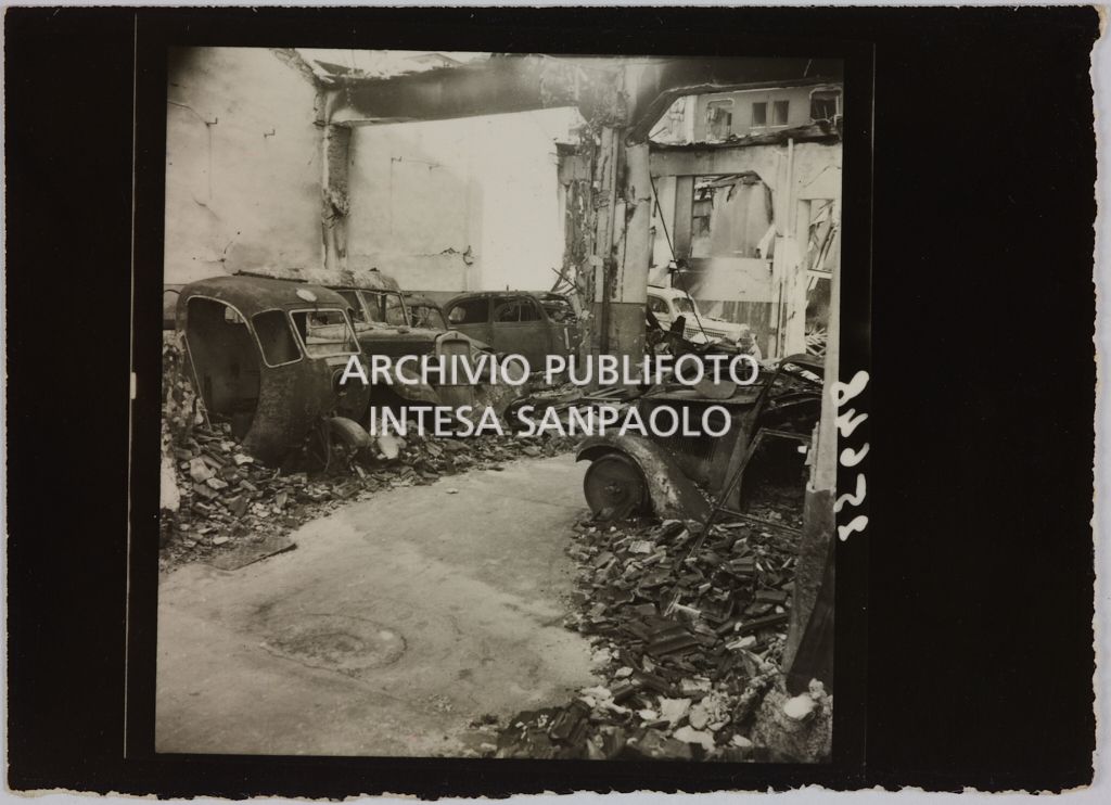 Automobili ricoverate presso l'autorimessa di proprietà della Rinascente, in viale Coni Zugna a Milano, distrutte dai bombardamenti che hanno colpito l'edificio