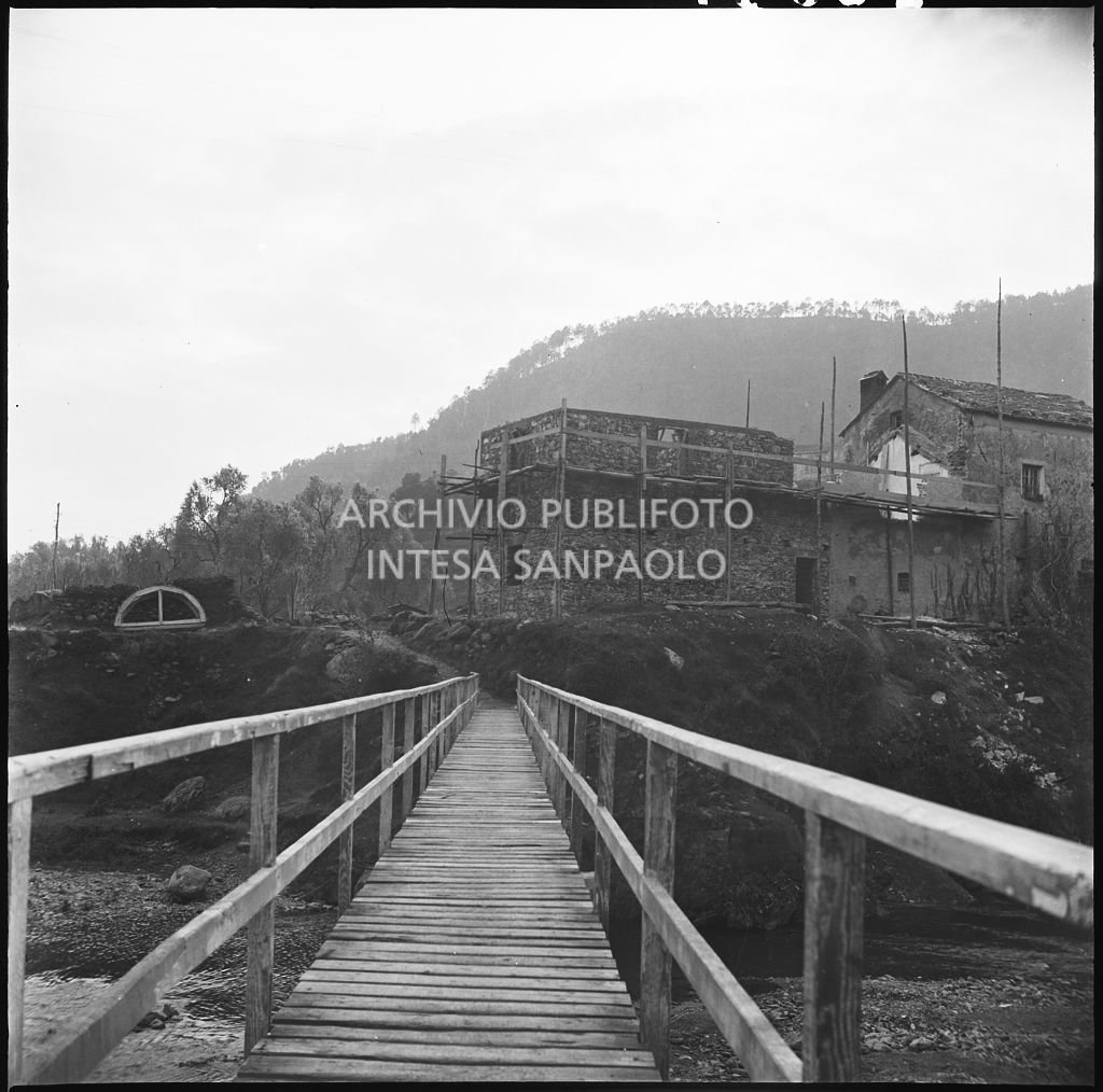 Ponte pedonale che attraversa il torrente nei pressi dello stabilimento Belsana che si intravede sullo sfondo<br>26691