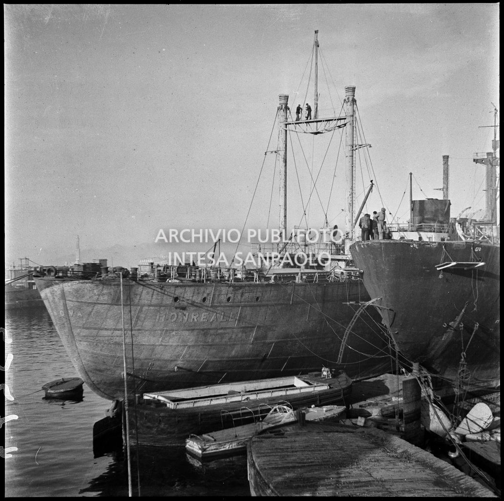 Uomini al lavoro su una nave mercantile nel bacino di riparazione nel porto di Genova. Sulla sinistra il mercantile Monreale<br>23277