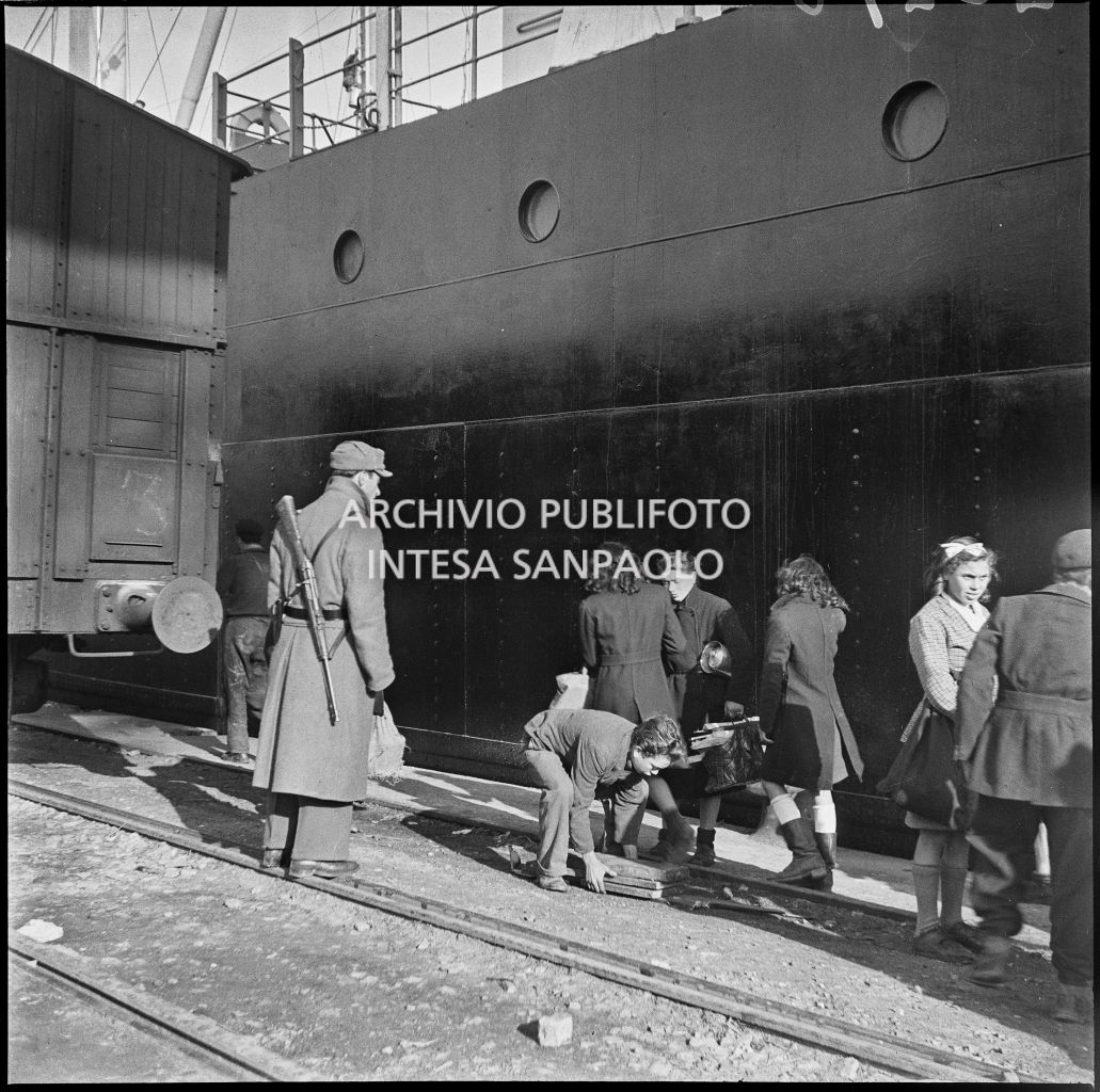 Un poliziotto di pattuglia al porto di Genova osserva alcune persone di passaggio<br>23278