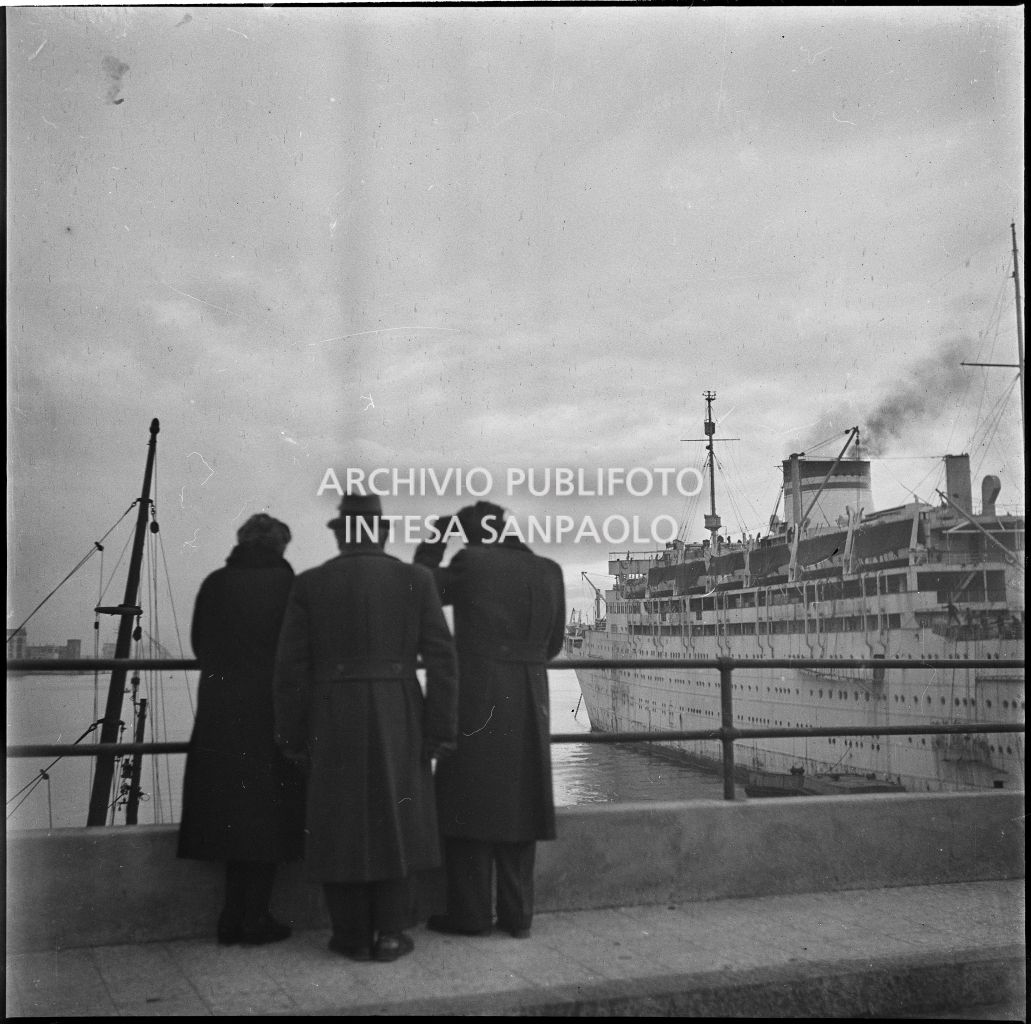 Alcune persone al porto di Genova guardano una nave passeggeri ormeggiata<br>23286