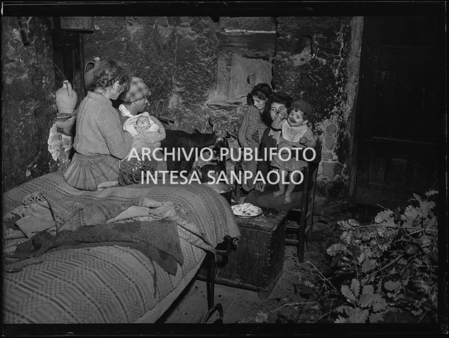 Africo, interno: famiglia con neonato, bambino, ragazzi e due capre