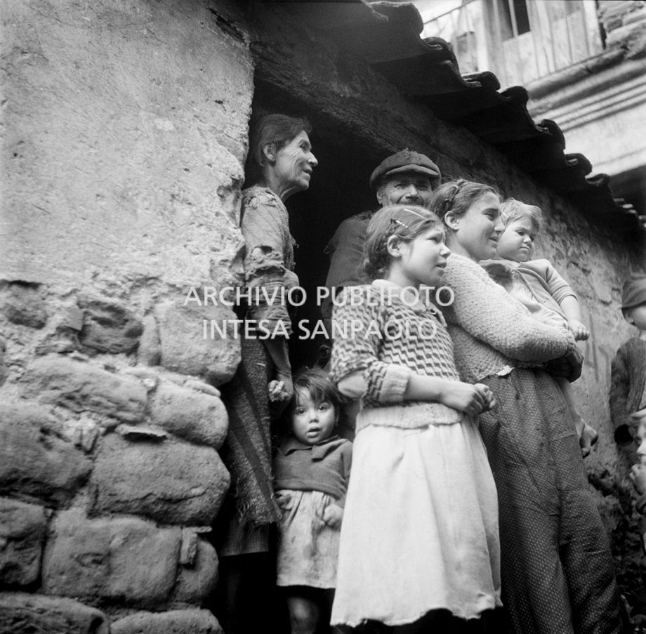Africo, donne, bambini e un uomo sulla soglia di casa