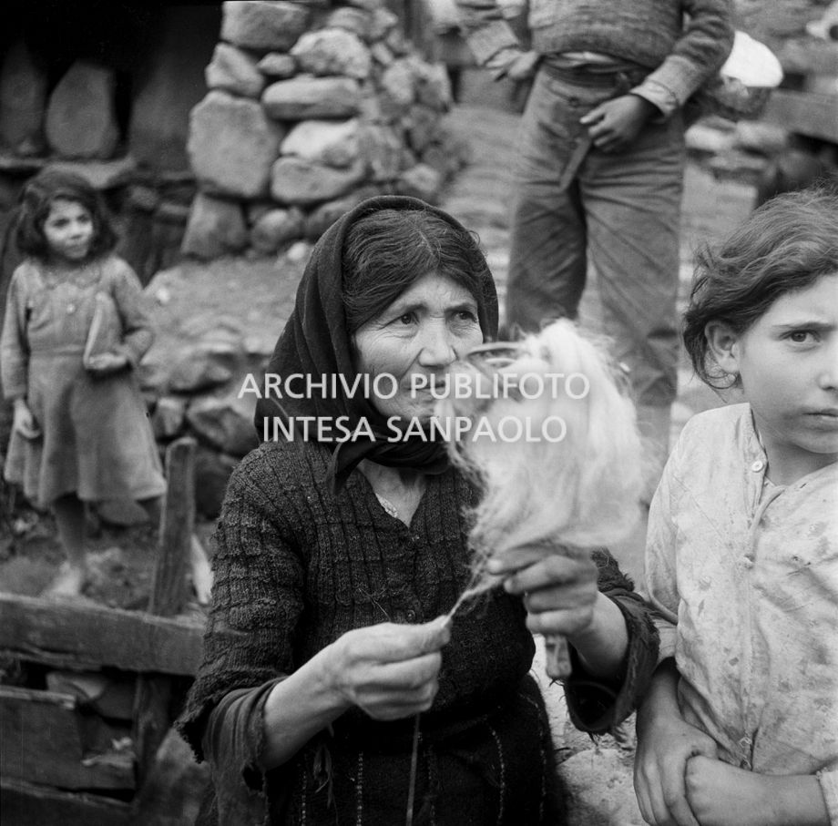 Africo, ritratto di donna con in mano un fuso di filato