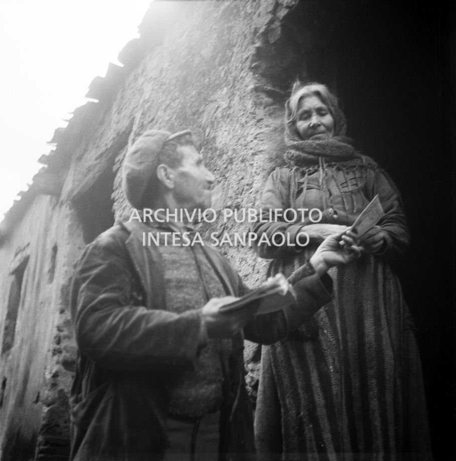 Africo, un uomo mostra un foglio a una donna sulla soglia di casa