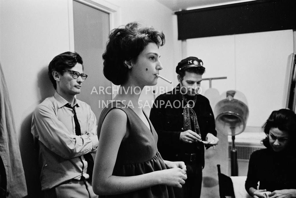 Benedetta Barzini in camerino con la sigaretta in bocca; alle sue spalle Richard Avedon, sullo sfondo due collaboratori<br>727793/28