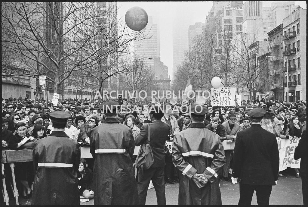 Polizia in servizio alla marcia contro la guerra in Vietnam, a New York, promossa dallo Spring Mobilization Committee; sullo sfondo migliaia di dimostranti arrivati in prossimità del Palazzo della Nazioni Unite dove parleranno gli oratori