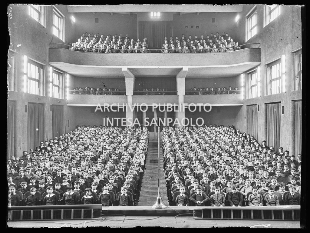 Bambini, ragazzi e adulti seduti nella platea di un teatro