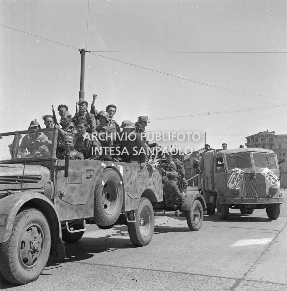 Ingresso a Milano delle colonne partigiane: su un autocarro i manifesti con la scritta: "Raggruppamento A. Di Dio Alto Milanese"