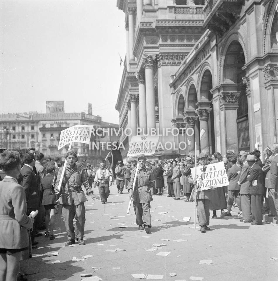 Sfilata in piazza del Duomo a Milano delle formazioni partigiane con cartelli e bandiere