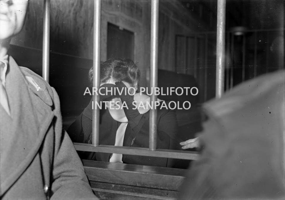 Caterina Fort, al processo in Corte d'Assise a Milano, nella gabbia degli imputati, si copre il viso