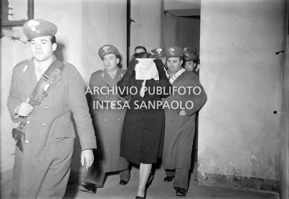 Caterina Fort, al processo in Corte d'Assise a Milano, scortata dai carabinieri, si copre il viso con la sciarpa