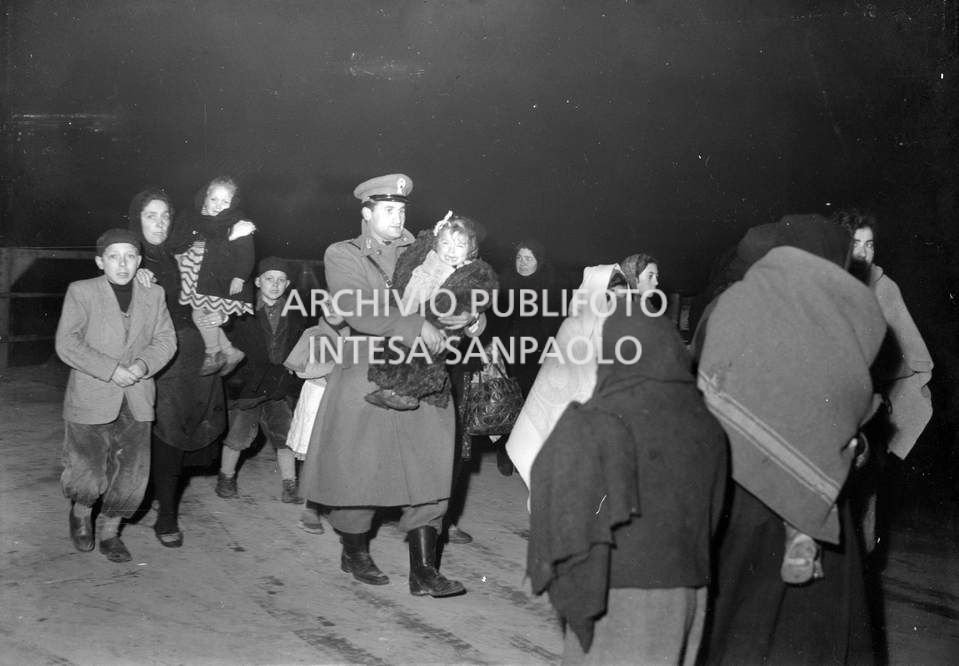 Un carabiniere con in braccio una bambina tra gli alluvionati del Polesine
