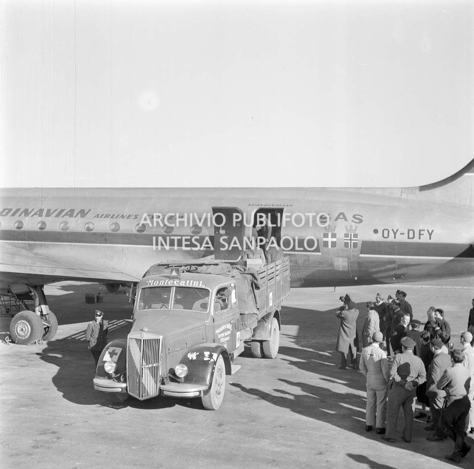 Aereo della Scandinavian Airlines System (SAS) all'aeroporto di Malpensa con gli aiuti inviati dalla Norvegia, agli alluvionati del Polesine; questi vengono caricati su un autocarro della Montecatini<br>113375