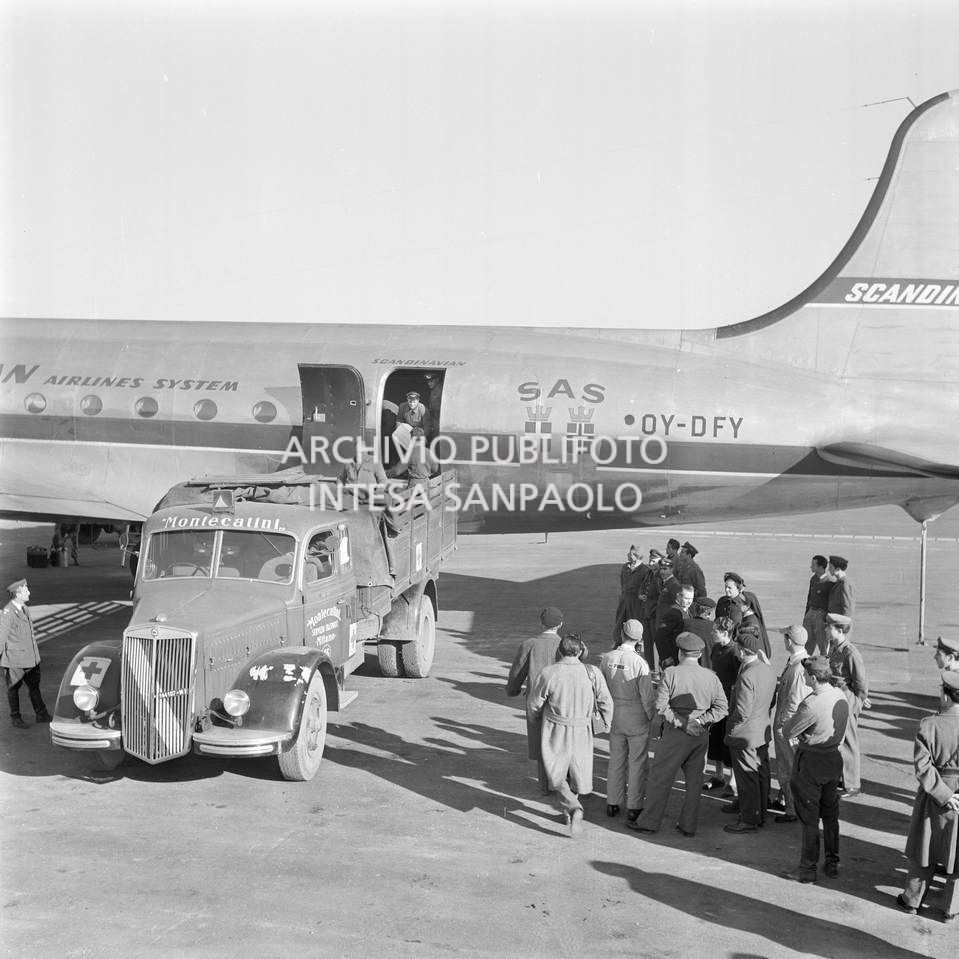 Aereo della Scandinavian Airlines System (SAS) all'aeroporto di Malpensa con gli aiuti inviati dalla Norvegia, agli alluvionati del Polesine; questi vengono caricati su un autocarro della Montecatini<br>113381