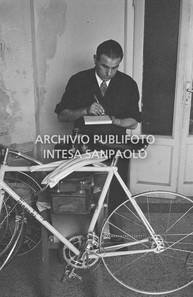 Il meccanico Giuseppe De Grandi, detto Pinella, prepara la bicicletta di Roger Rivière in vista del record dell'ora che il ciclista francese si sarebbe aggiudicato di lì a tre giorni