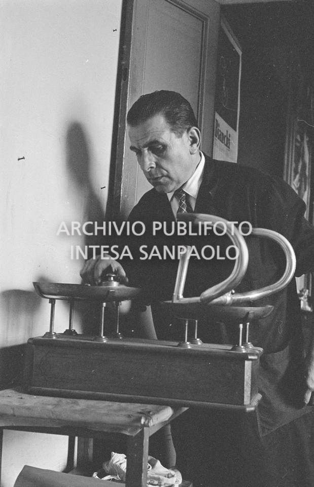 Il meccanico Giuseppe De Grandi, detto Pinella, pesa il manubrio di una bicicletta durante la preparazione di quella per Roger Rivière con la quale,  di lì a tre giorni, il ciclista francese si sarebbe aggiudicato il record dell'ora