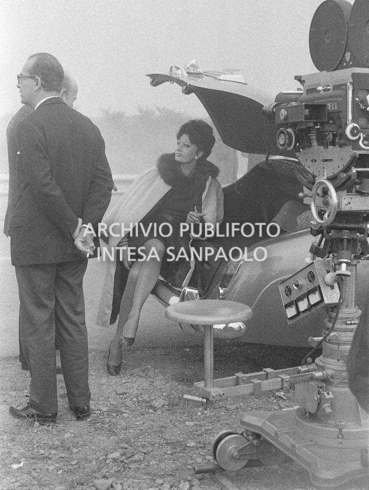 Sophia Loren, con la sigaretta in mano, con Armando Trovajoli, durante le riprese del secondo episodio, ambientato a Milano, del film "Ieri, oggi, domani" del regista Vittorio De Sica. A destra la cinepresa su carrello