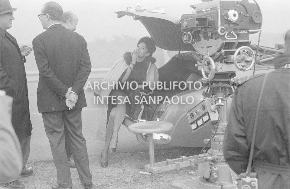 Sophia Loren con Armando Trovajoli, mentre fuma, durante le riprese del secondo episodio, ambientato a Milano, del film "Ieri, oggi, domani" del regista Vittorio De Sica. A destra la cinepresa su carrello