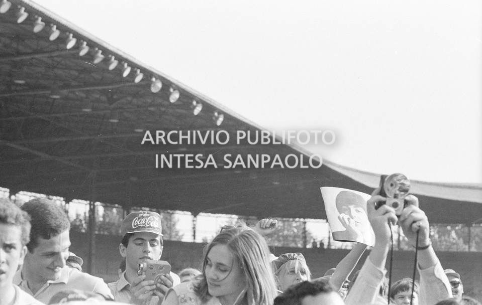 Fan scatenati al concerto pomeridiano dei Beatles al Vigorelli di Milano: una ragazza mostra una fotografia di Paul McCartney