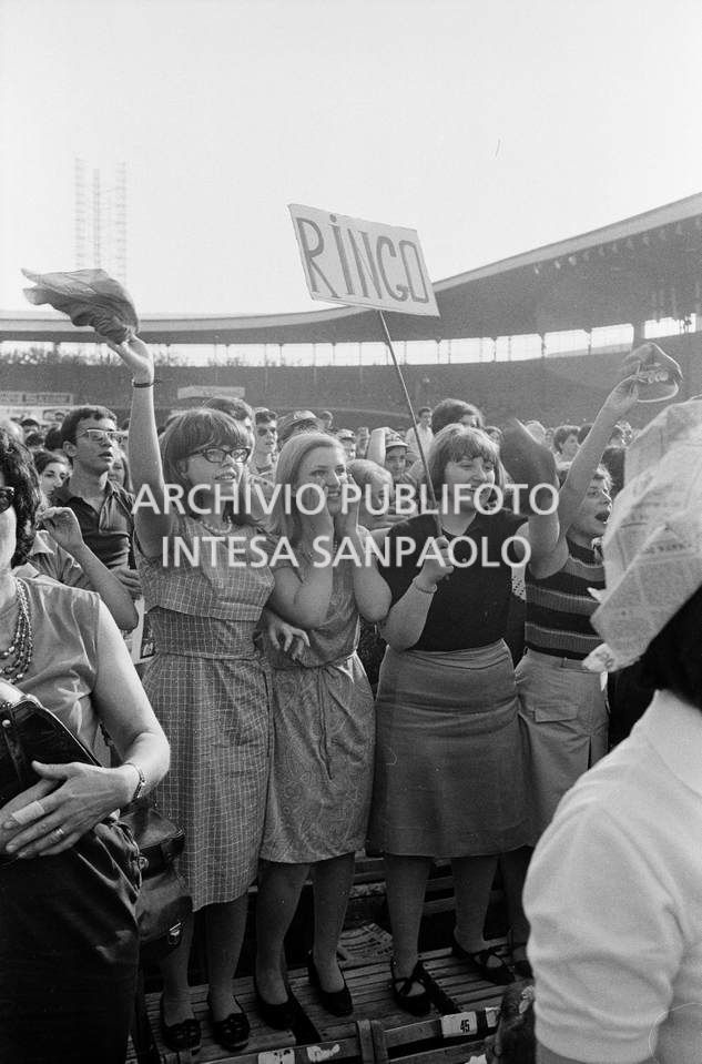 Tre sostenitrici di Ringo Starr con un cartello a lui dedicato tra il pubblico al concerto pomeridiano dei Beatles al Vigorelli di Milano