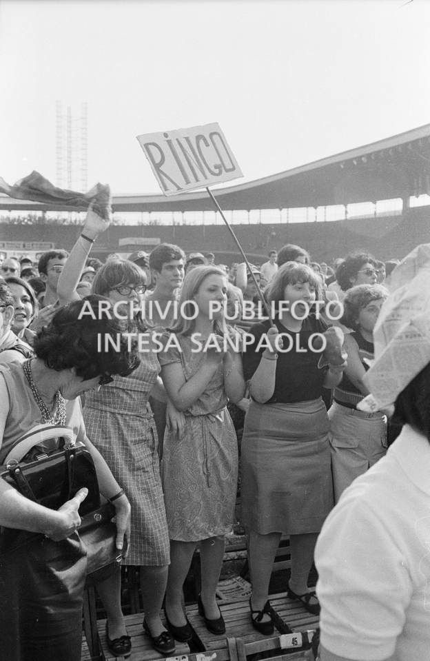 Tre sostenitrici di Ringo Starr con un cartello a lui dedicato tra il pubblico al concerto pomeridiano dei Beatles al Vigorelli di Milano
