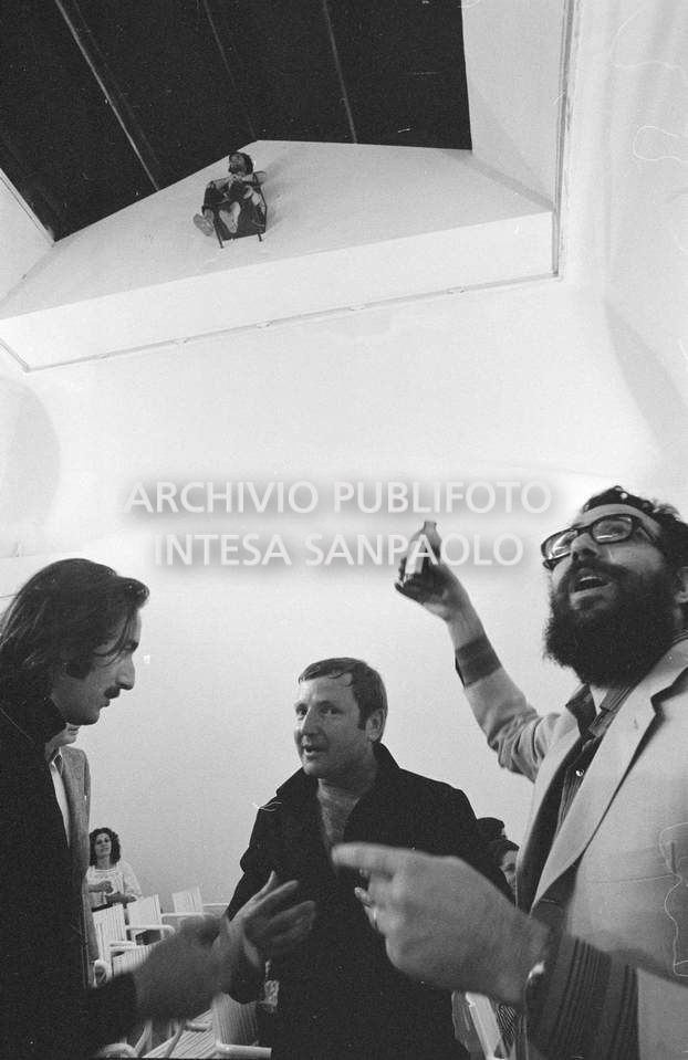 Gino De Dominicis (a sinistra) in compagnia di due visitatori, nella sala che ospita la sua composizione vivente installata alla XXXVI Biennale internazionale d'arte di Venezia; uno dei due visitatori brinda all'opera