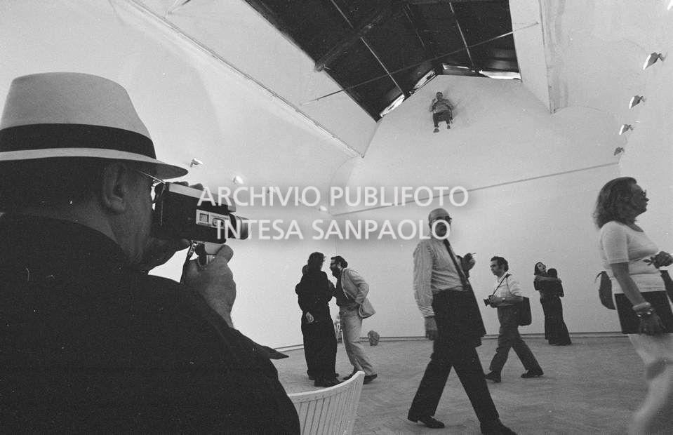 Visitatore riprende con una cinepresa amatoriale la composizione vivente di Gino De Dominicis installata alla XXXVI Biennale internazionale d'arte di Venezia e i visitatori