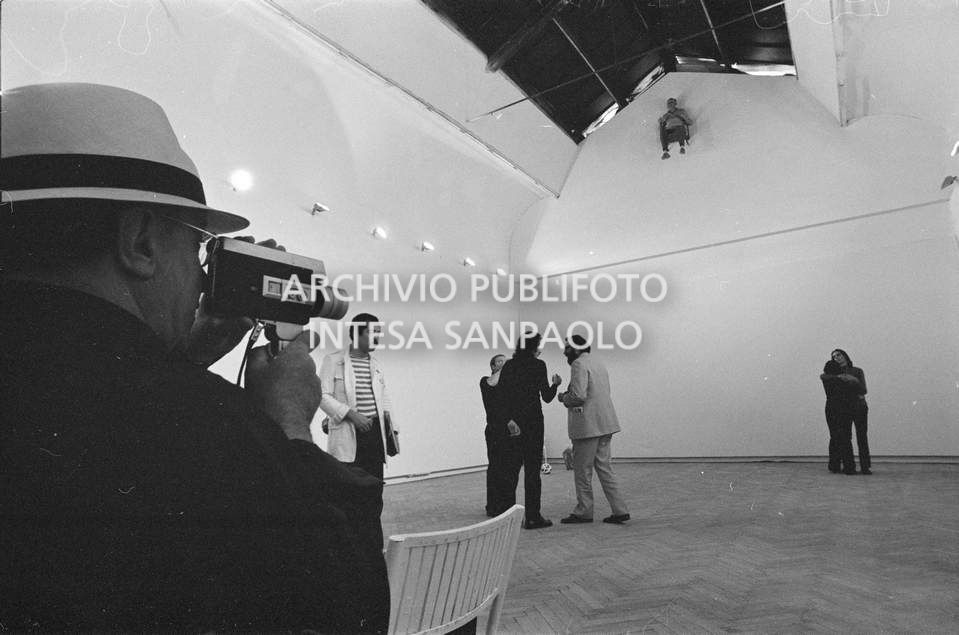 Visitatore riprende con una cinepresa amatoriale la composizione vivente di Gino De Dominicis installata alla XXXVI Biennale internazionale d'arte di Venezia e i visitatori