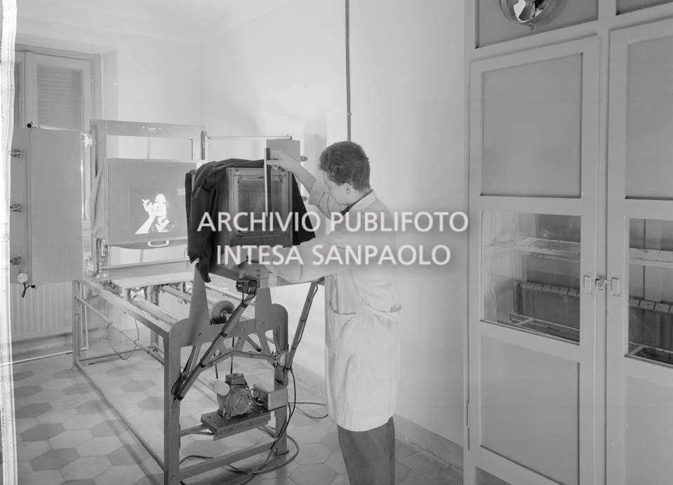 Un addetto al lavoro nella sala riproduzioni presso l'agenzia Publifoto in via Bramante a Milano