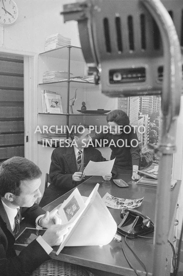 Nick Giordano, Anna Petrelli e un altro uomo al lavoro presso l'agenzia Publifoto, in via Bramante a Milano