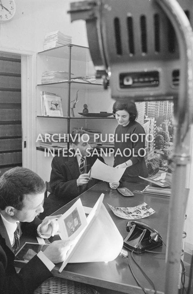 Nick Giordano, Anna Petrelli e un altro uomo al lavoro presso l'agenzia Publifoto, in via Bramante a Milano