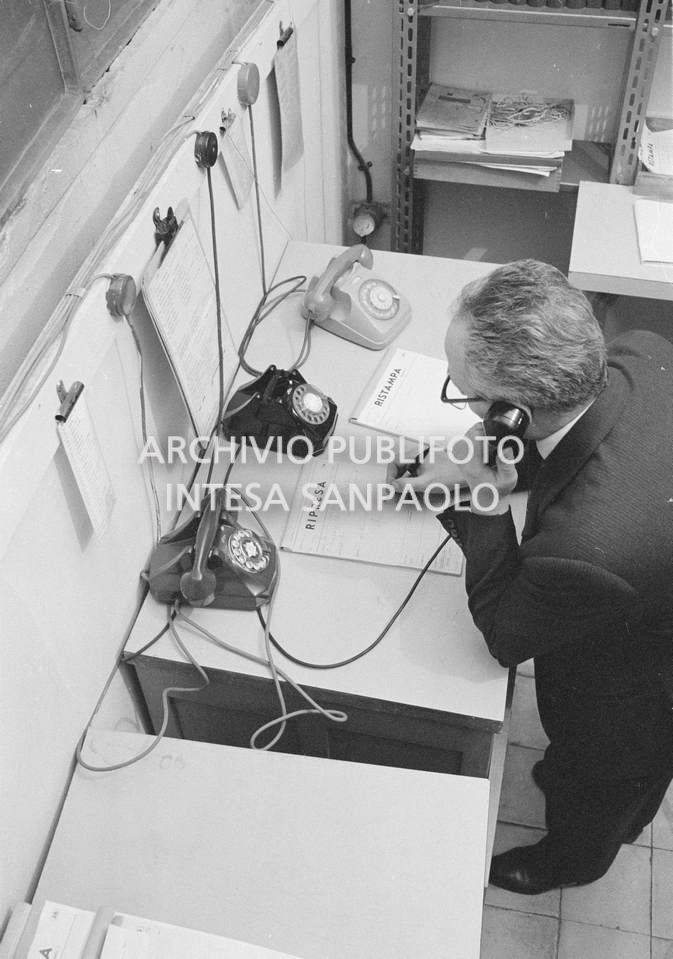 Peppino Giovi al telefono presso l'agenzia Publifoto, in via Bramante a Milano