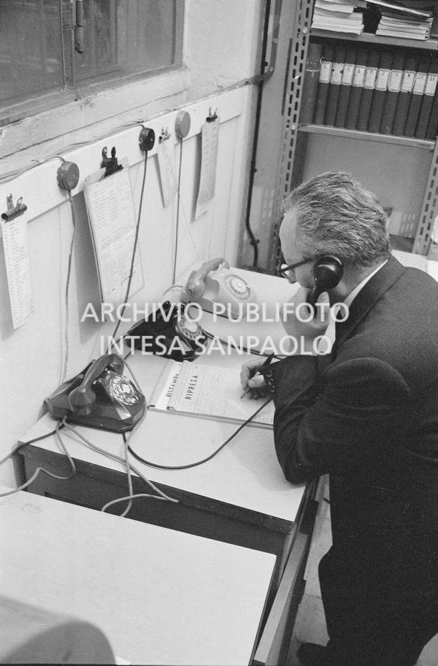 Peppino Giovi al telefono presso l'agenzia Publifoto, in via Bramante a Milano