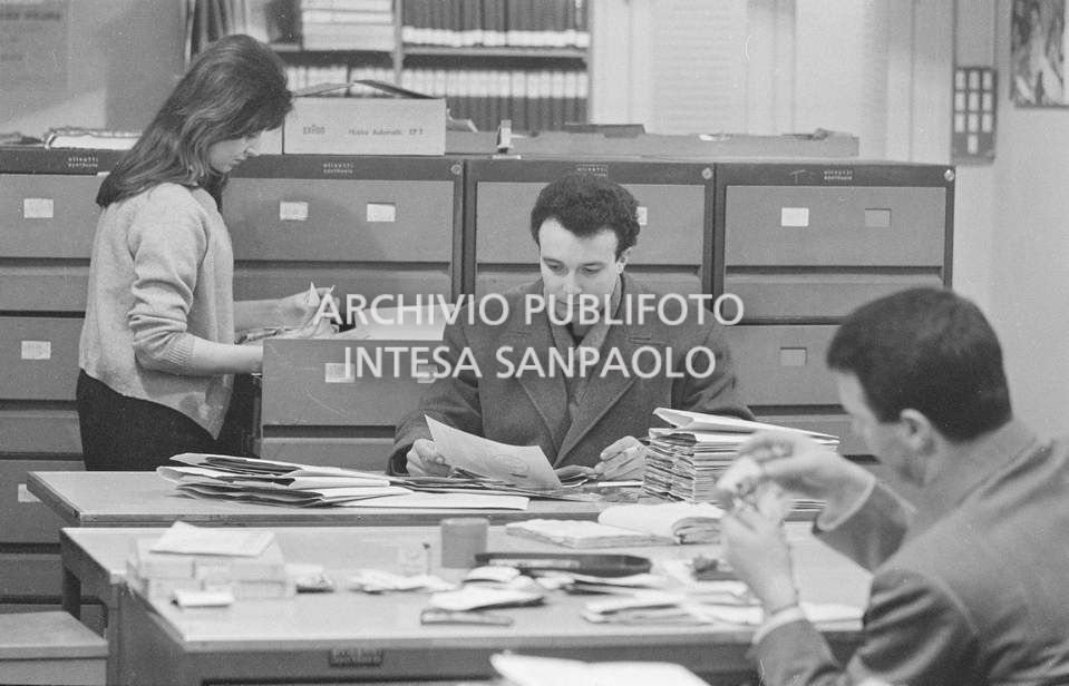L'archivio dell'agenzia Publifoto nella sede di via Bramante a Milano: a destra di spalle Nick Giordano, al centro Gabriele Milani che finge di essere un cliente che cerca fotografie