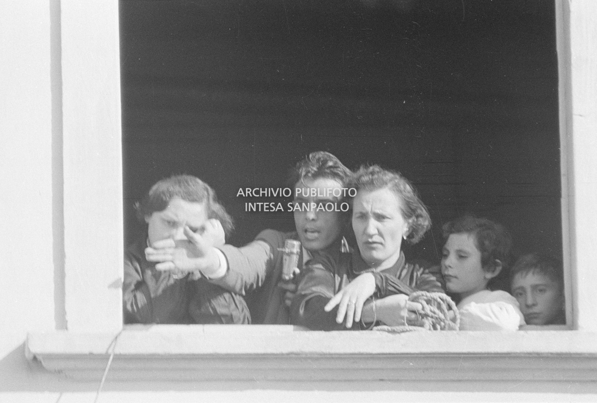 Due maestre della scuola elementare di Terrazzano, frazione di Rho in provincia di Milano, affacciate alla finestra a fianco a Arturo Santato, al microfono, che, con il fratello Egidio, le tiene in ostaggio con gli alunni e un'altra maestra