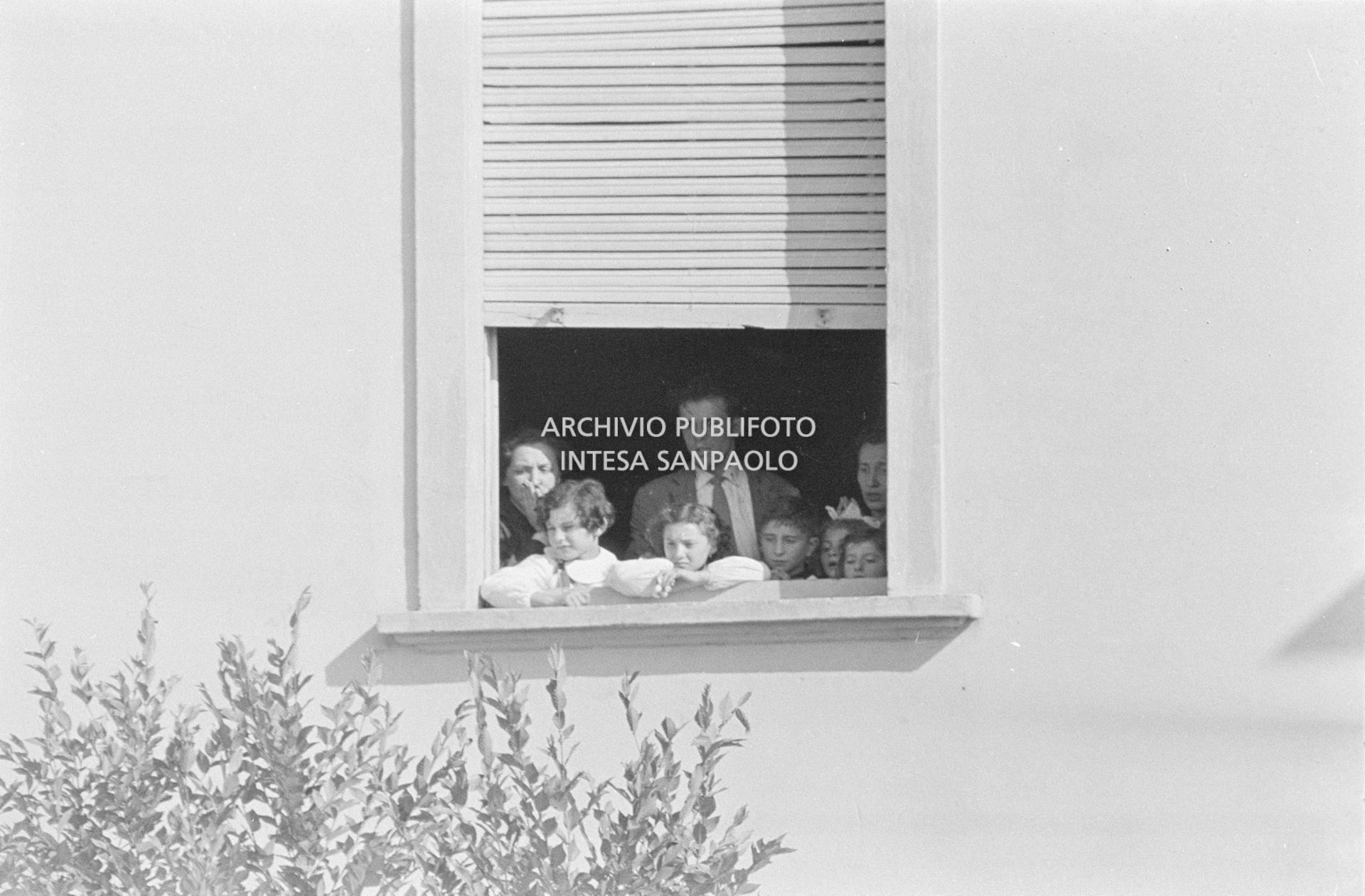 Alcuni alunni e due maestre, a una finestra della scuola elementare di Terrazzano, frazione di Rho in provincia di Milano, a fianco ad Arturo Santato, che, insieme al fratello Egidio, tiene in ostaggio gli alunni e le maestre