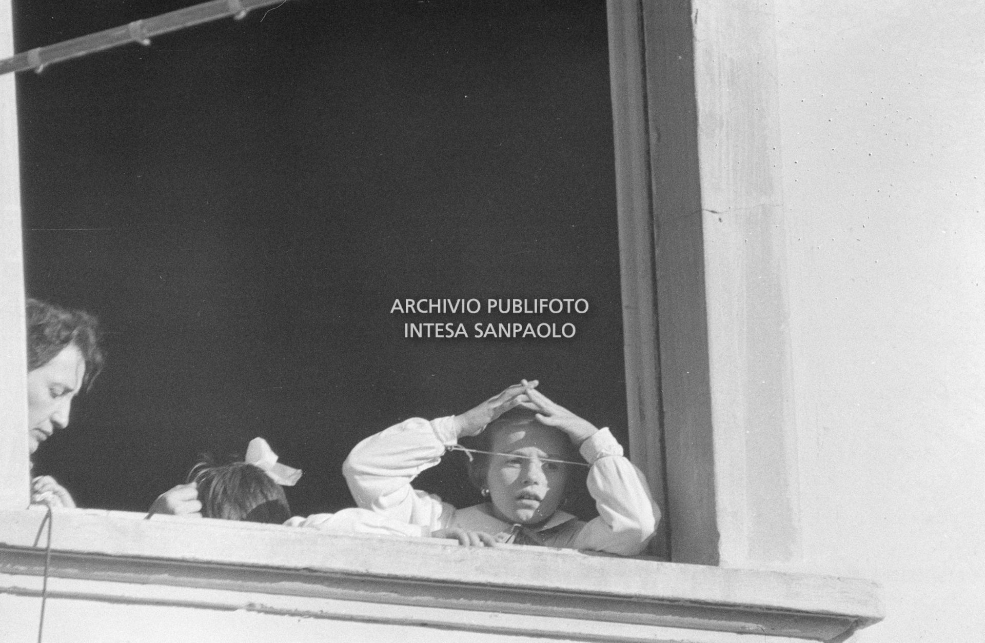 Una bambina guarda fuori dalla finestra della scuola elementare di Terrazzano, frazione di Rho in provincia di Milano, dove è tenuta in ostaggio insieme a 96 suoi compagni e a tre maestre dai due fratelli Santato