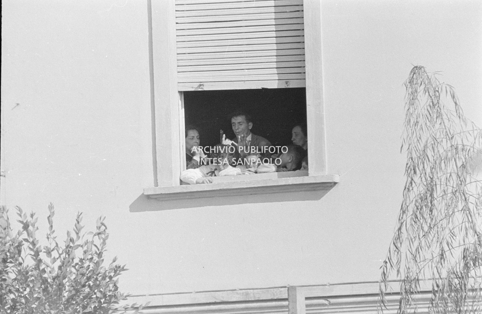 Alcuni alunni e due maestre, a una finestra della scuola elementare di Terrazzano, frazione di Rho in provincia di Milano, a fianco ad Arturo Santato, che, insieme al fratello Egidio, tiene in ostaggio gli alunni e le maestre