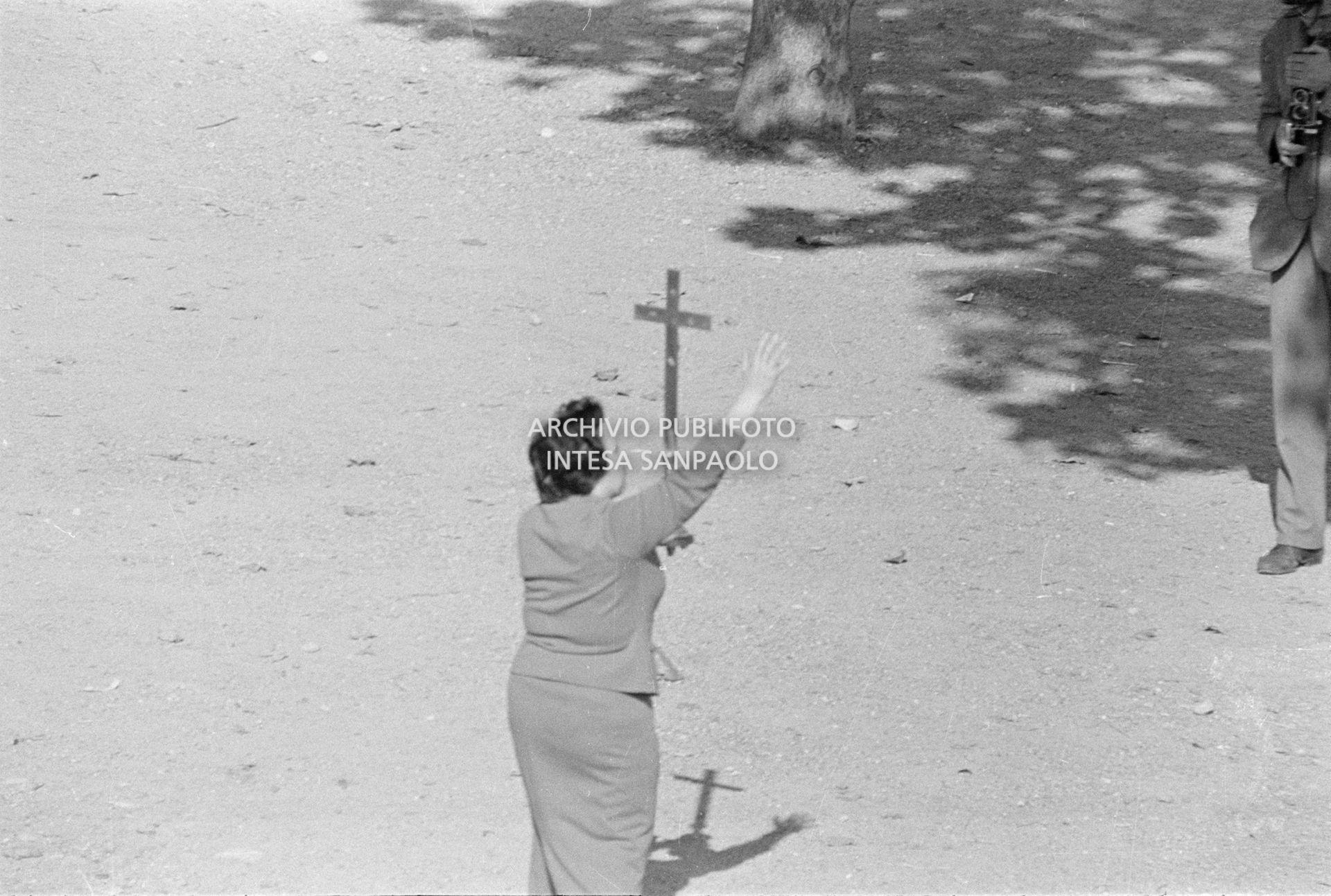 Una donna impugna un crocifisso nei pressi della scuola elementare di Terrazzano, frazione di Rho in provincia di Milano, dove i due fratelli Santato tengono in ostaggio tre maestre e agli alunni