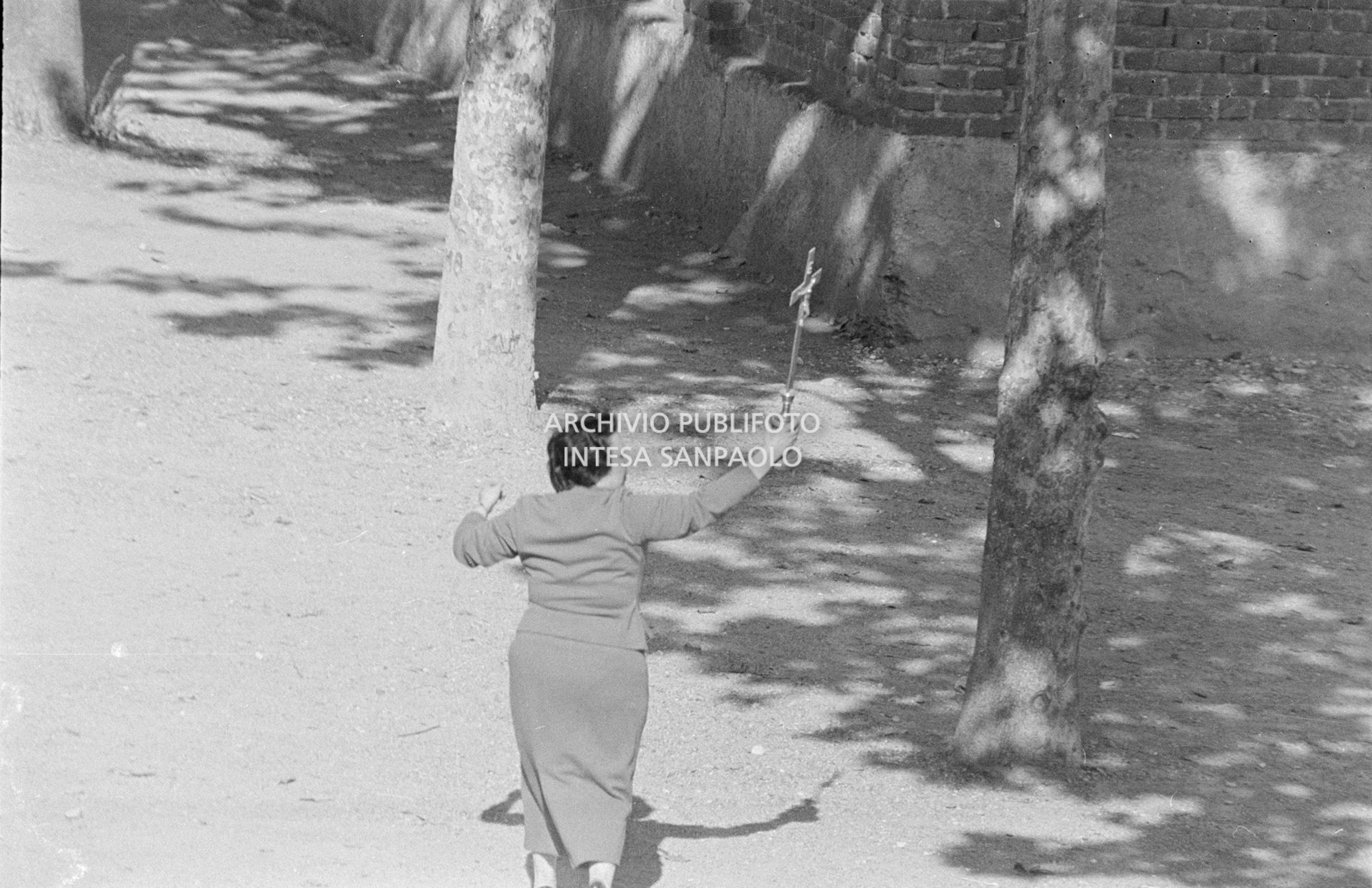 Una donna impugna un crocifisso nei pressi della scuola elementare di Terrazzano, frazione di Rho in provincia di Milano, dove i due fratelli Santato tengono in ostaggio tre maestre e agli alunni