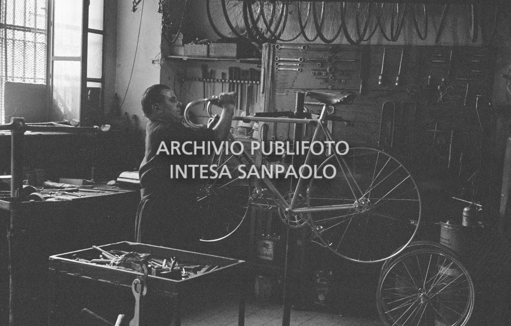 Il meccanico Giuseppe De Grandi, detto Pinella, prepara la bicicletta di Roger Rivière in vista del record dell'ora che il ciclista francese si sarebbe aggiudicato di lì a tre giorni
