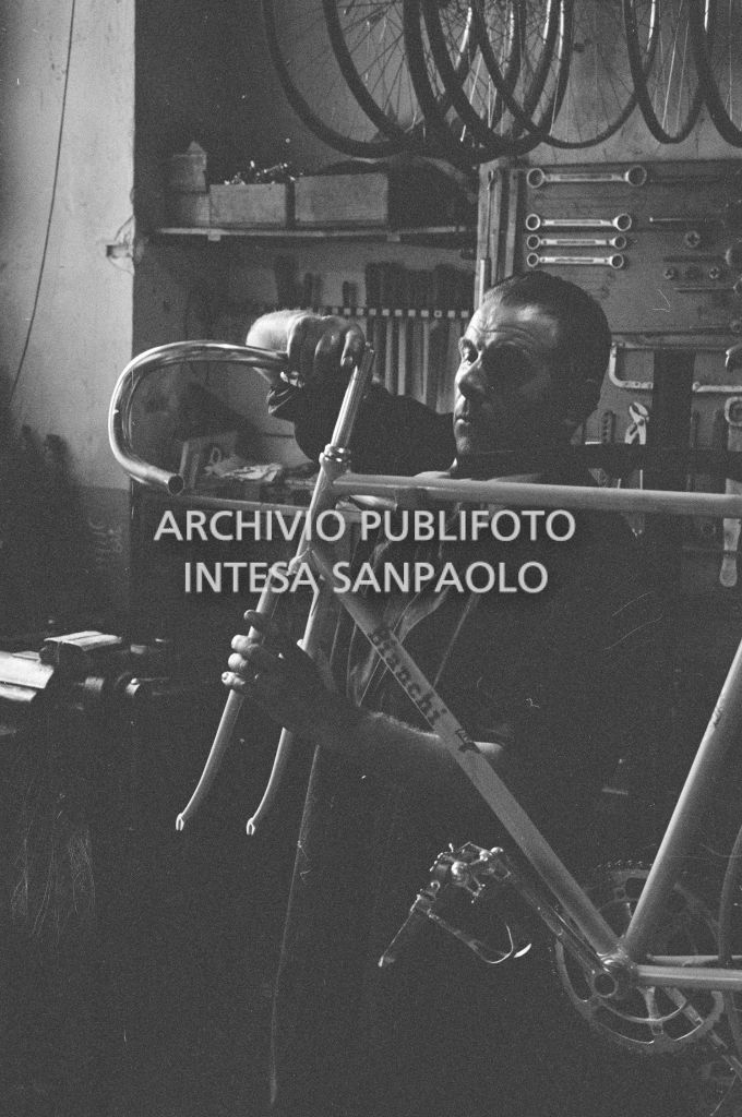 Il meccanico Giuseppe De Grandi, detto Pinella, prepara la bicicletta di Roger Rivière in vista del record dell'ora che il ciclista francese si sarebbe aggiudicato di lì a tre giorni