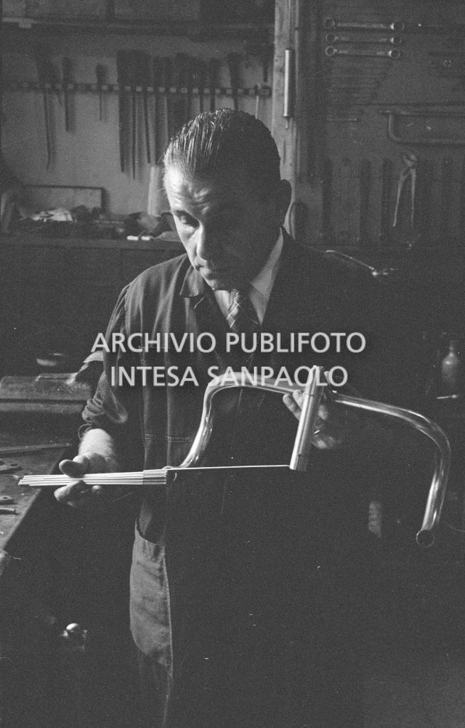 Il meccanico Giuseppe De Grandi, detto Pinella, prepara la bicicletta di Roger Rivière in vista del record dell'ora che il ciclista francese si sarebbe aggiudicato di lì a tre giorni